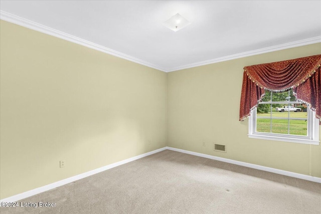 carpeted spare room with visible vents, baseboards, and ornamental molding
