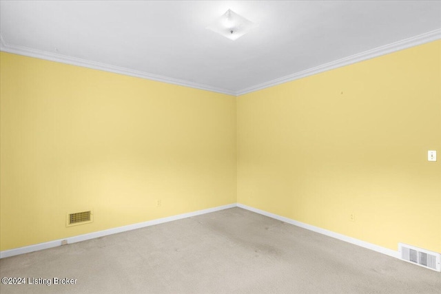 spare room featuring visible vents, baseboards, light colored carpet, and crown molding