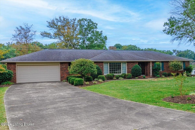 ranch-style home featuring a garage, driveway, brick siding, and a front lawn