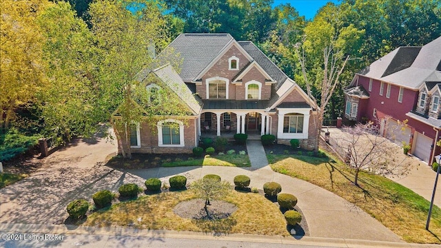 view of front of house with a garage, covered porch, and a front yard