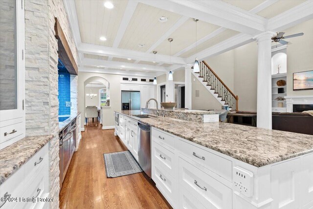 kitchen featuring white cabinets, hardwood / wood-style floors, beamed ceiling, a large island, and ceiling fan