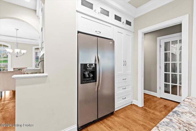 kitchen with light hardwood / wood-style flooring, pendant lighting, stainless steel fridge, and white cabinets