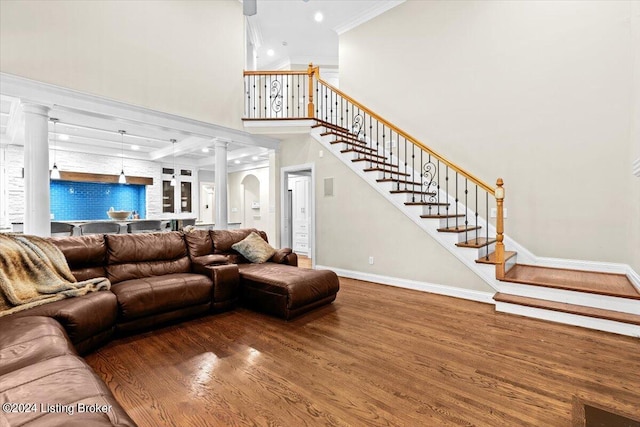 living room with ornamental molding, hardwood / wood-style flooring, and ornate columns