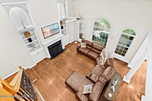 living room with a high ceiling, ceiling fan, and hardwood / wood-style flooring