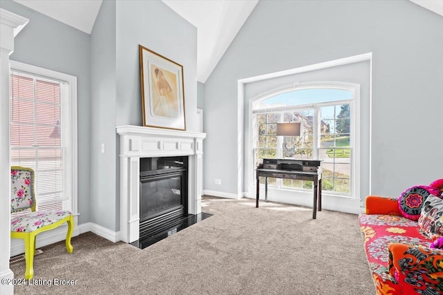 carpeted living area with a fireplace with flush hearth, baseboards, and vaulted ceiling