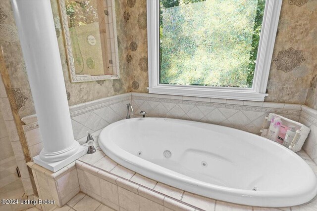 bathroom featuring tiled tub and ornate columns