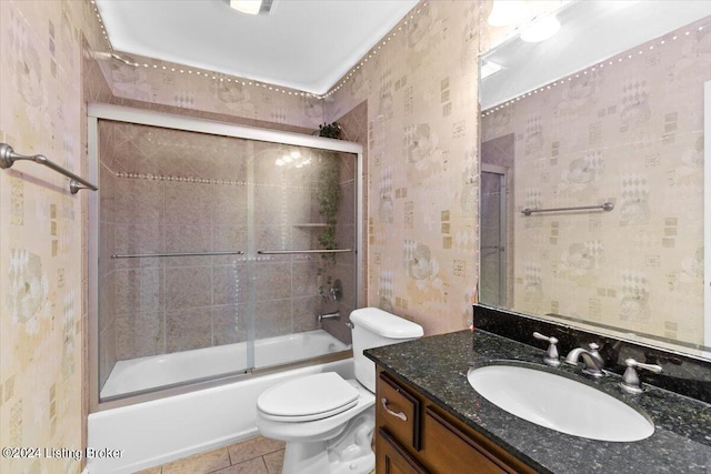 full bathroom with tile patterned floors, toilet, bath / shower combo with glass door, and vanity