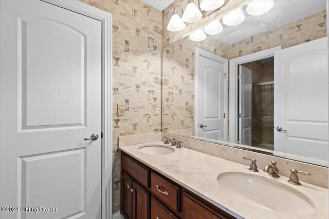 bathroom with a shower with shower door and vanity