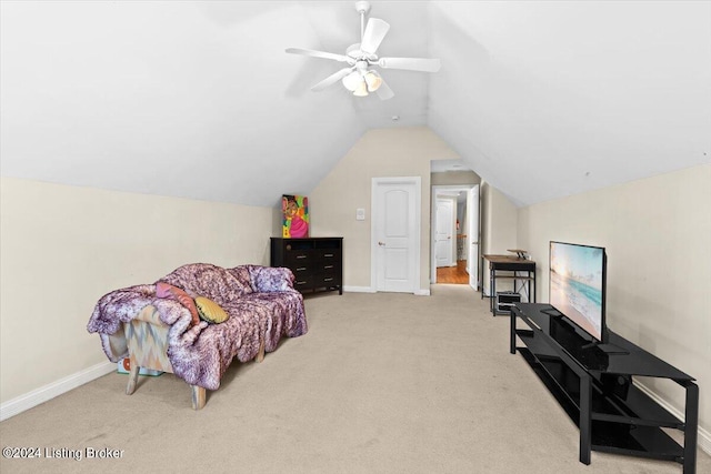 living area featuring vaulted ceiling, ceiling fan, and light colored carpet