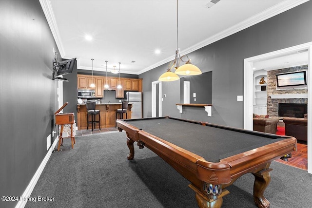 game room with built in shelves, baseboards, recessed lighting, a stone fireplace, and crown molding