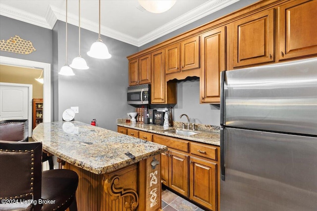 kitchen featuring a kitchen bar, stainless steel appliances, sink, light stone countertops, and hanging light fixtures