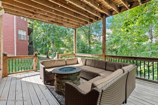 wooden terrace featuring an outdoor living space with a fire pit