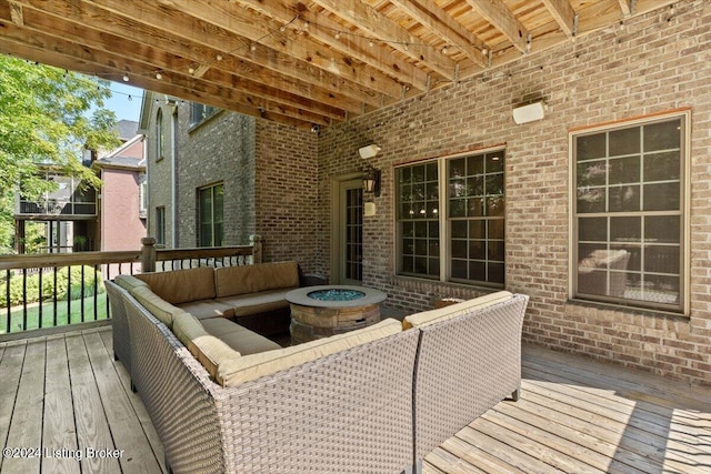 wooden deck with an outdoor living space with a fire pit