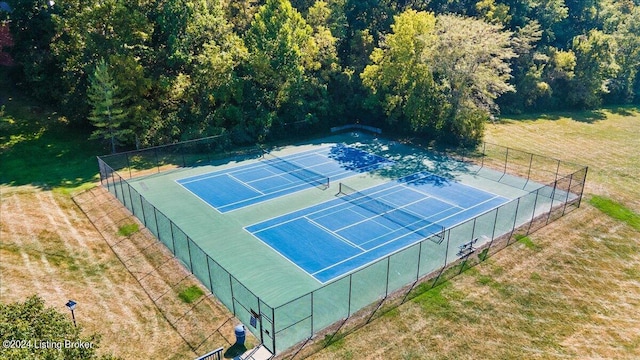 view of tennis court featuring a lawn