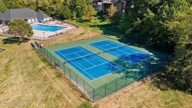 view of sport court with a community pool, a yard, and fence