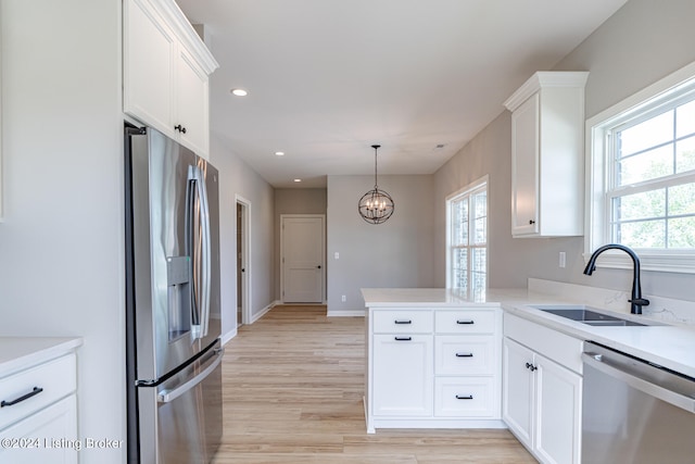 kitchen featuring sink, white cabinetry, kitchen peninsula, light hardwood / wood-style flooring, and stainless steel appliances