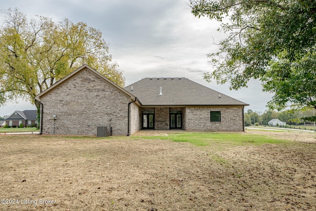 back of house featuring a lawn and central AC