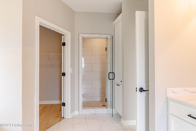 bathroom featuring hardwood / wood-style floors, a shower with door, and vanity