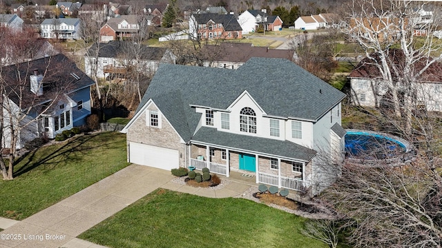 view of front facade featuring covered porch, a garage, and a front yard