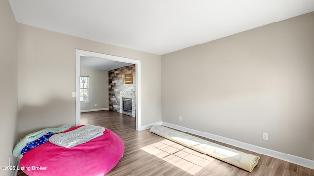 sitting room with hardwood / wood-style floors and a large fireplace