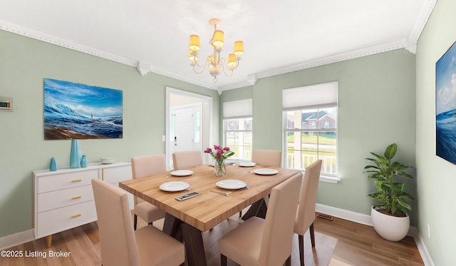 dining room featuring an inviting chandelier, light hardwood / wood-style flooring, and ornamental molding