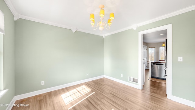 spare room featuring ornamental molding, wood-type flooring, and an inviting chandelier