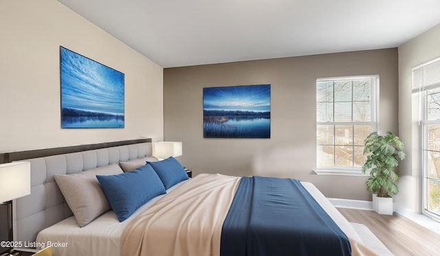 bedroom with light hardwood / wood-style flooring and multiple windows