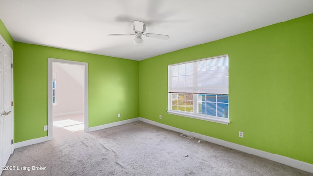 empty room featuring ceiling fan and light carpet