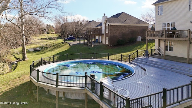 view of pool featuring a lawn and a wooden deck