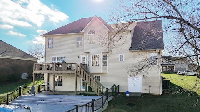 rear view of property featuring a yard, central AC unit, and a wooden deck