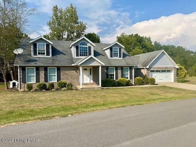 new england style home with a garage and a front yard