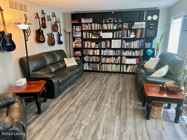 sitting room with a textured ceiling and hardwood / wood-style flooring