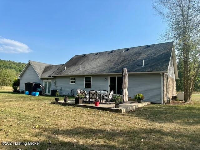 back of property with a lawn and a patio area