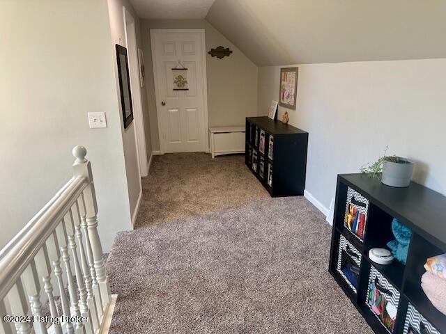 bonus room with lofted ceiling and carpet flooring