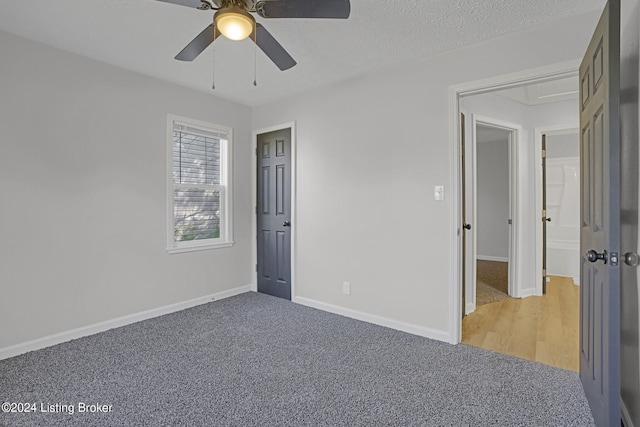 unfurnished bedroom with a textured ceiling, ceiling fan, and carpet floors