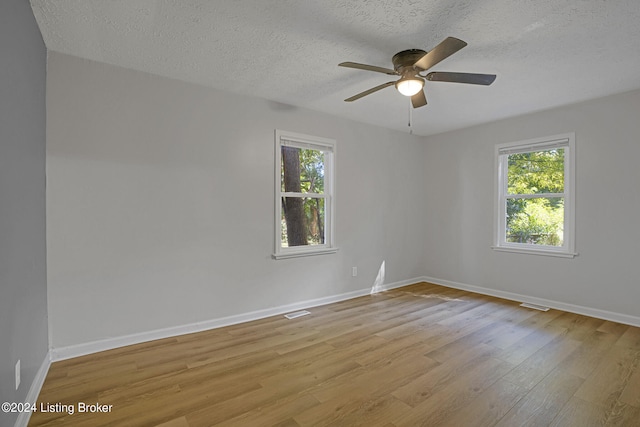 spare room featuring a textured ceiling, ceiling fan, and light wood-type flooring