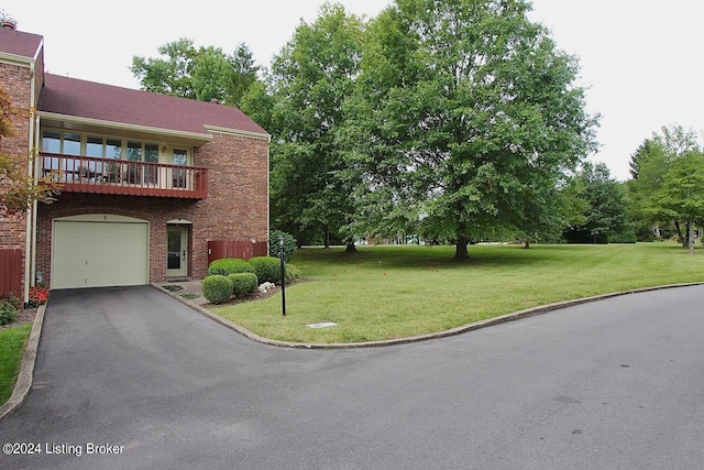 exterior space with a balcony, a garage, and a front lawn