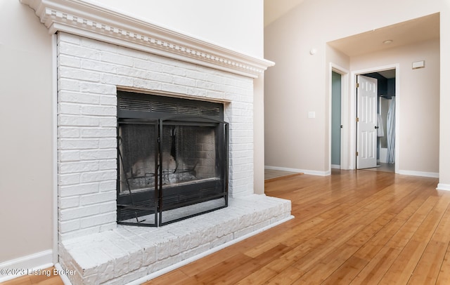 details with wood-type flooring and a brick fireplace