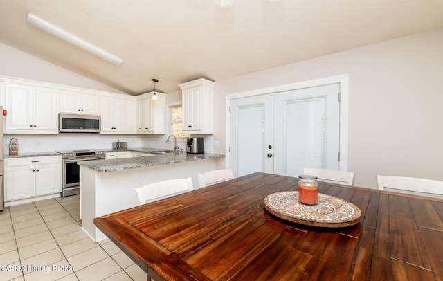 kitchen with hanging light fixtures, appliances with stainless steel finishes, light stone counters, sink, and kitchen peninsula