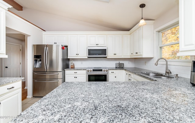 kitchen with vaulted ceiling, stainless steel appliances, sink, and decorative backsplash