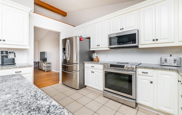 kitchen with lofted ceiling with beams, tasteful backsplash, light tile patterned floors, and stainless steel appliances