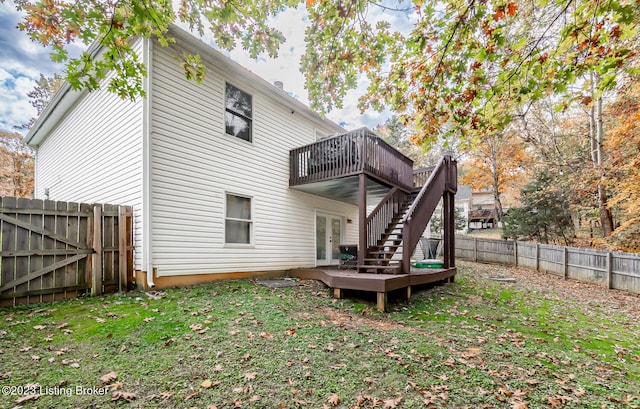 rear view of property featuring a lawn and a deck