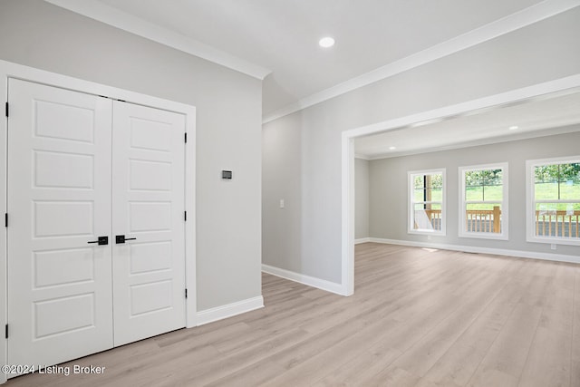 unfurnished room featuring ornamental molding and light hardwood / wood-style flooring