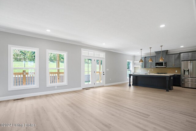 unfurnished living room featuring ornamental molding, light hardwood / wood-style flooring, and sink