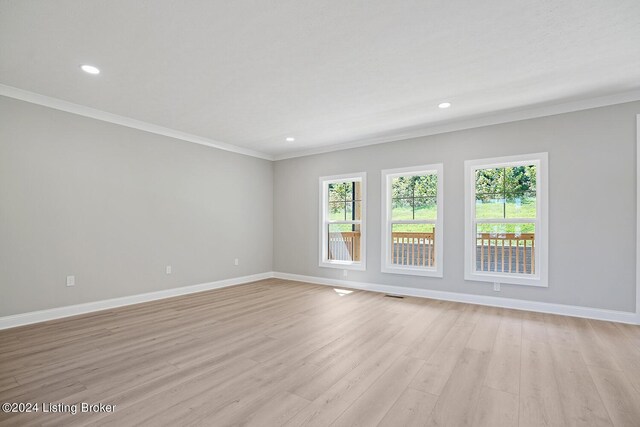 unfurnished room featuring ornamental molding and light wood-type flooring