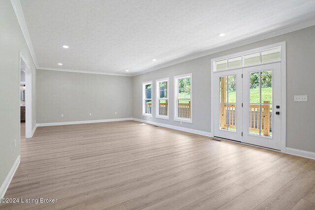 unfurnished living room featuring light hardwood / wood-style floors and crown molding