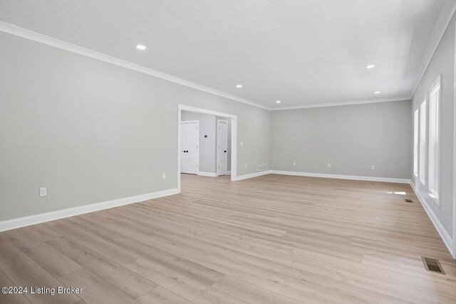 unfurnished room with crown molding and light hardwood / wood-style flooring