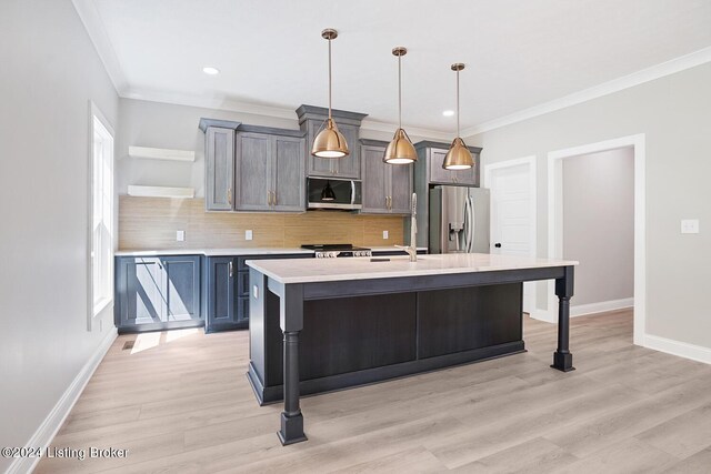 kitchen featuring appliances with stainless steel finishes, light hardwood / wood-style floors, a center island with sink, and a breakfast bar