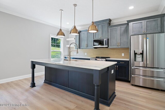 kitchen featuring pendant lighting, backsplash, appliances with stainless steel finishes, light hardwood / wood-style floors, and light stone counters