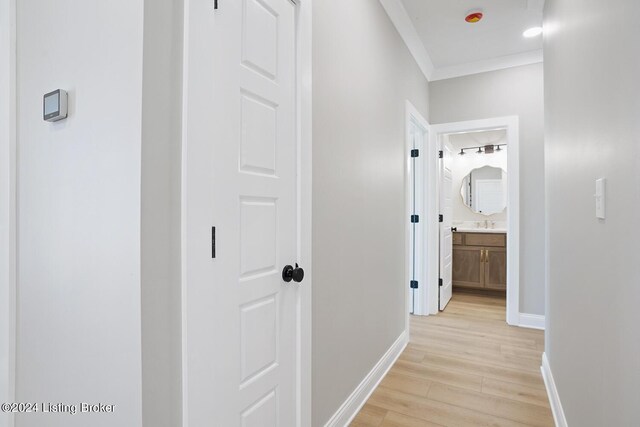 hall featuring crown molding, light hardwood / wood-style flooring, and sink